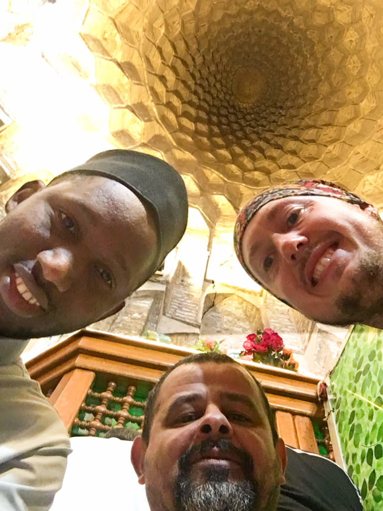 Me and two local visitors taking a selfie in the E Radeshams mosque with the inside of the dome in above us.