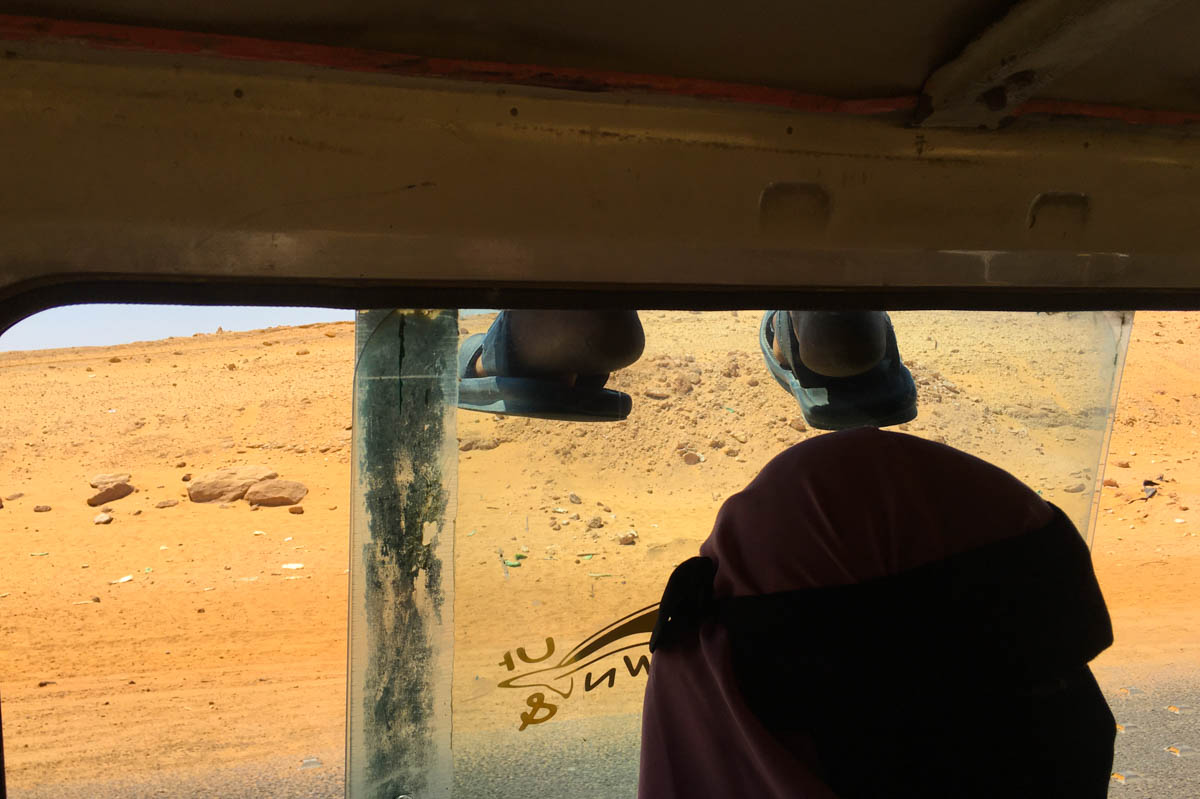 A pair of feet dangling over the side of the minibus