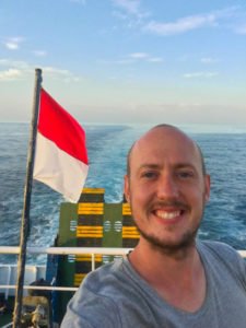 Me, standing on the ferry in the evening with an Indonesian flag blowing in the wind.