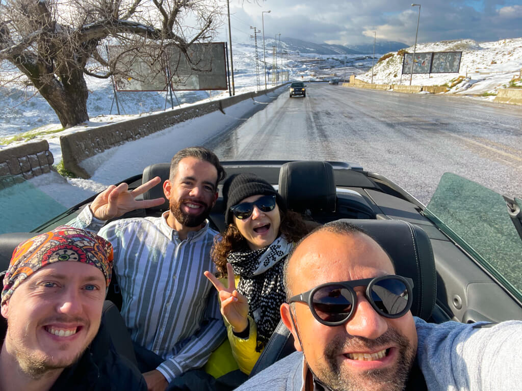 The four of us in our convertible car speeding over the mountains with snow on the ground