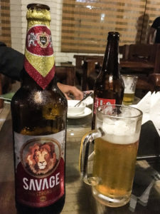 A bottle of Savage beer with a glass of beer standing next to it.