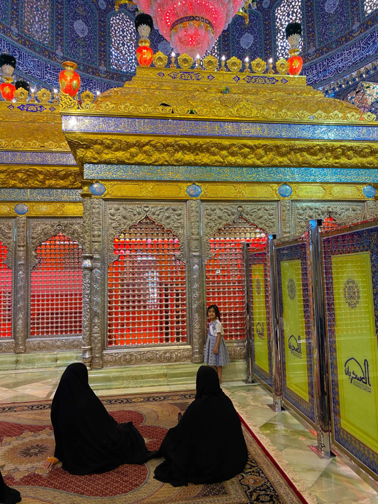 A little girl standing by the tomb of an imam in the colourful Al-Askari mosque.