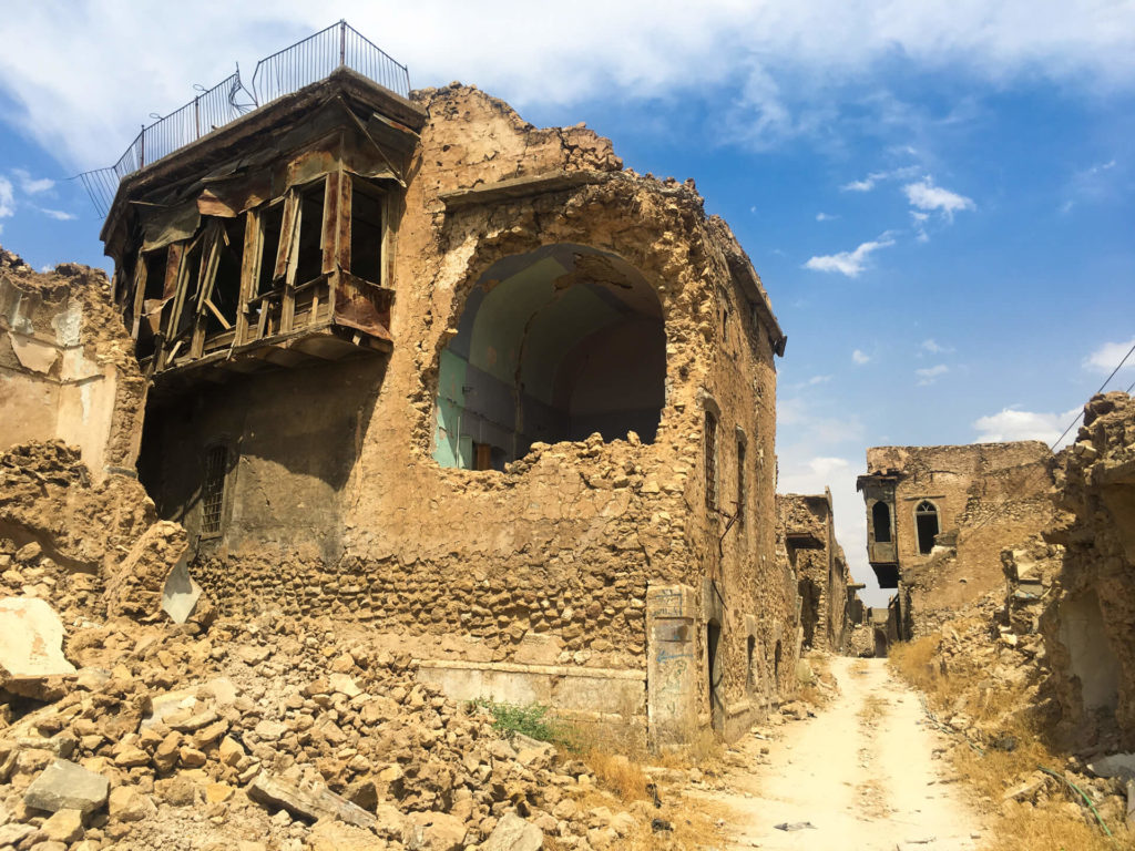 A narrow road winds between bombed out buildings in Mosul's old town.