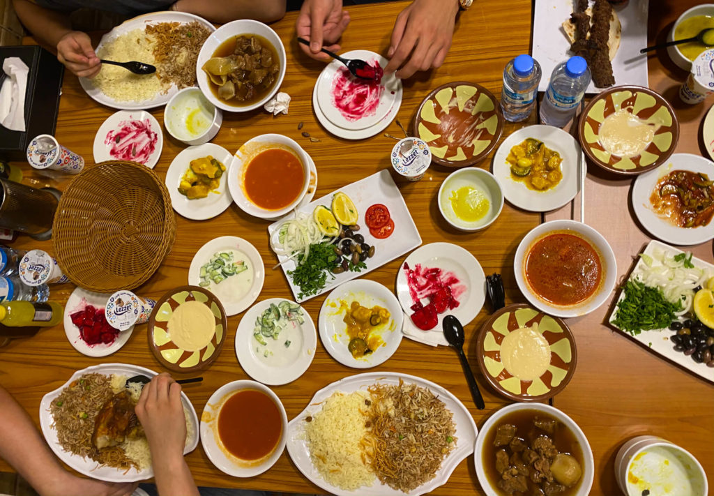 A table spread with many different and very colourful Iraqi dishes.