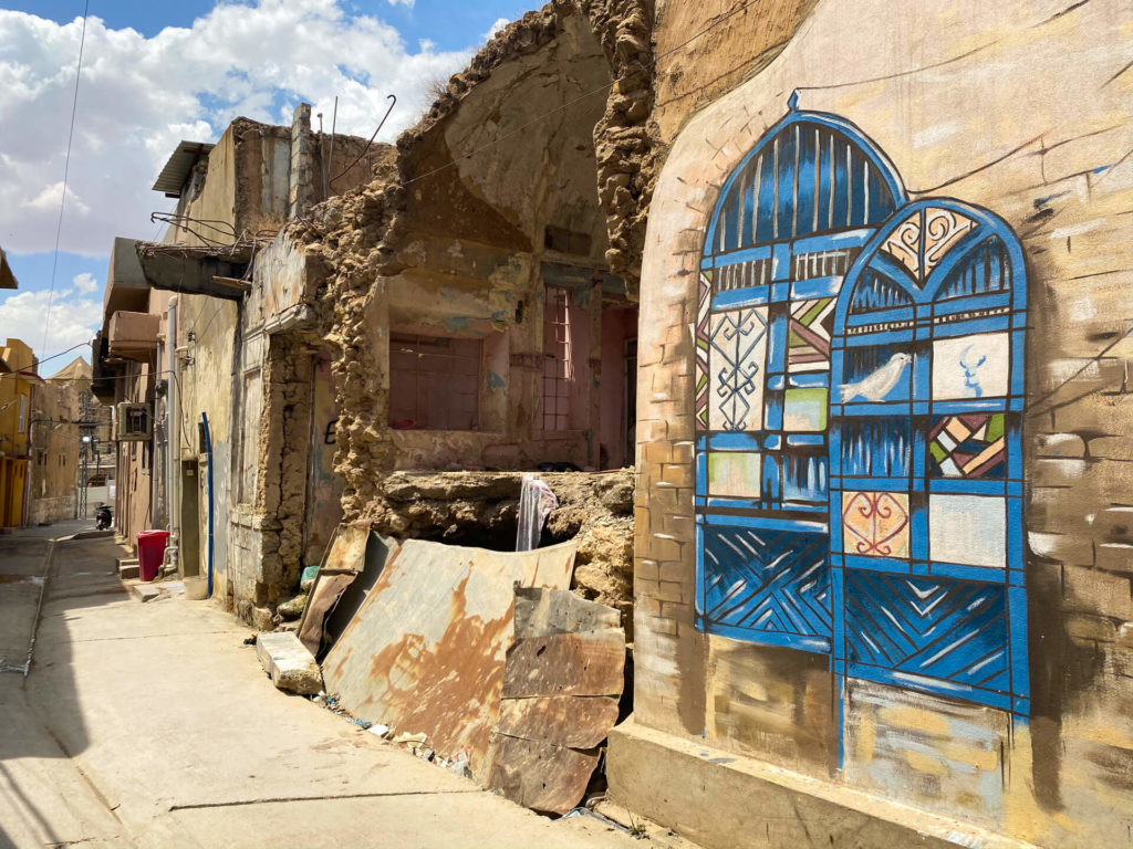 Blue graffiti next to a ruined building in Mosul's old town.