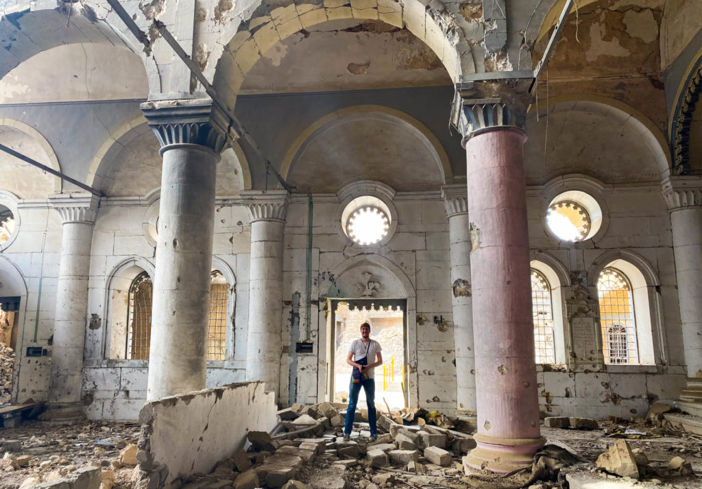 Me standing among the rubble of a badly damaged church in Mosul.  The building still stands, but some of the walls are destroyed.