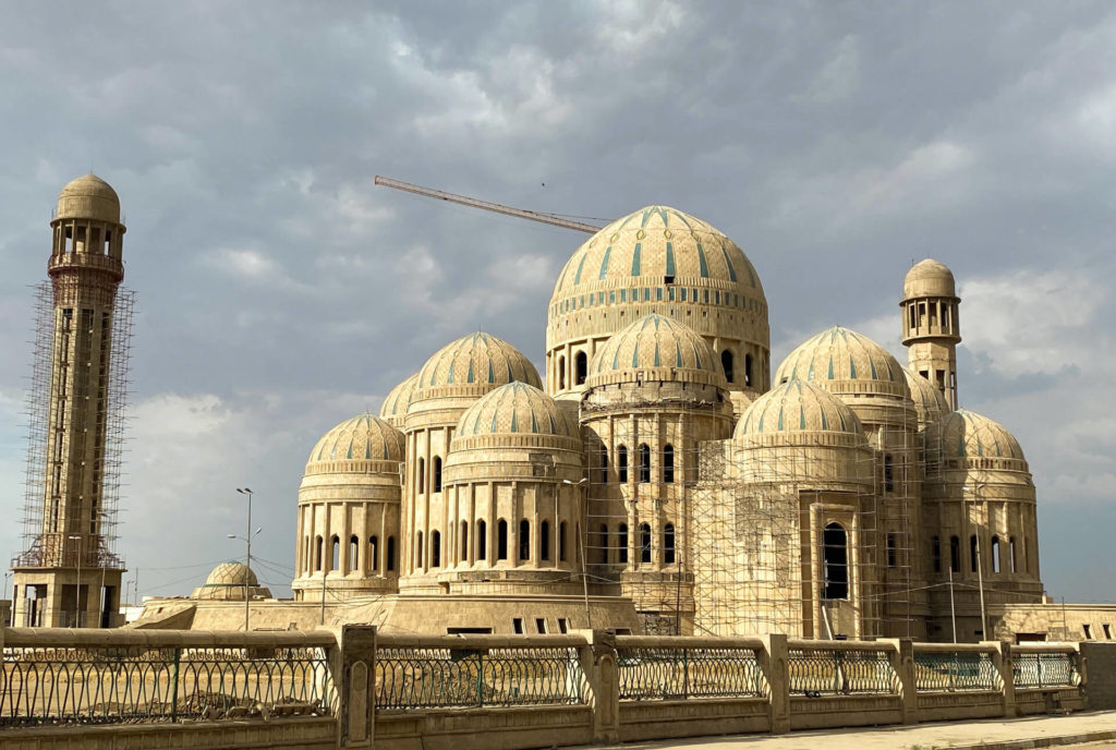 The multi-domed Mosul Grand Mosque with a crane in the background and scaffolding visible on one of its minarets. 