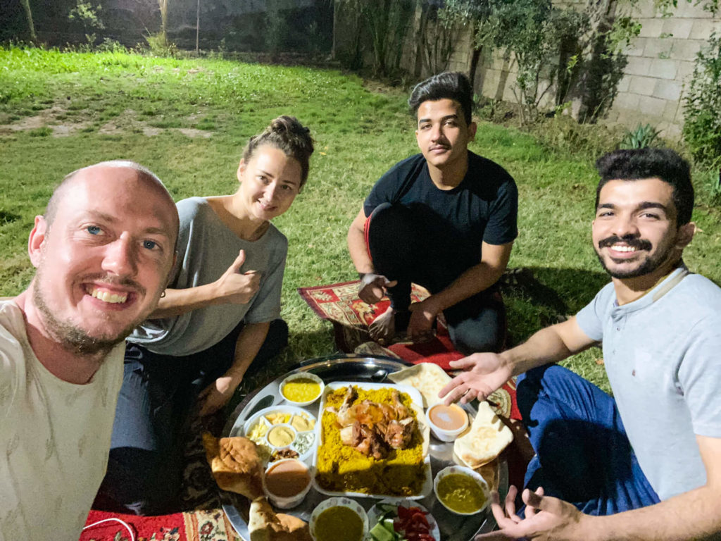 Me, Anna, Haydir and his brother eating dinner on carpets in the garden of Haydir's family's house.