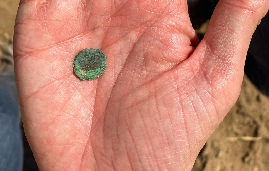 An ancient coin lying on the palm of my hand.