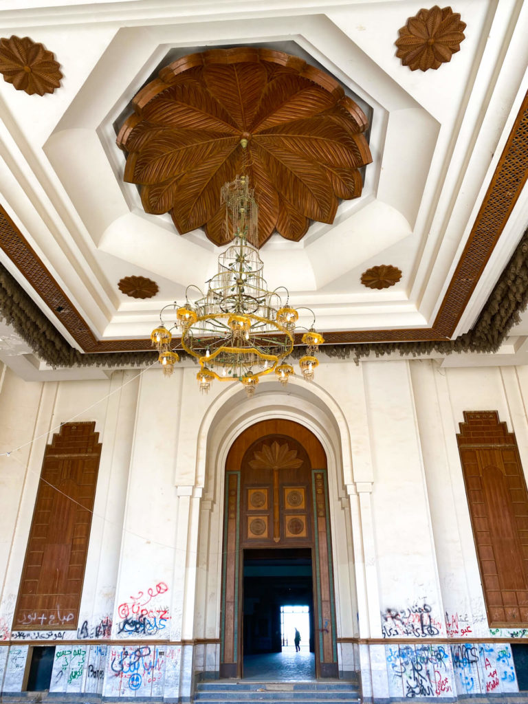 A huge room inside the palace with wooden panelling and a chandelier.  