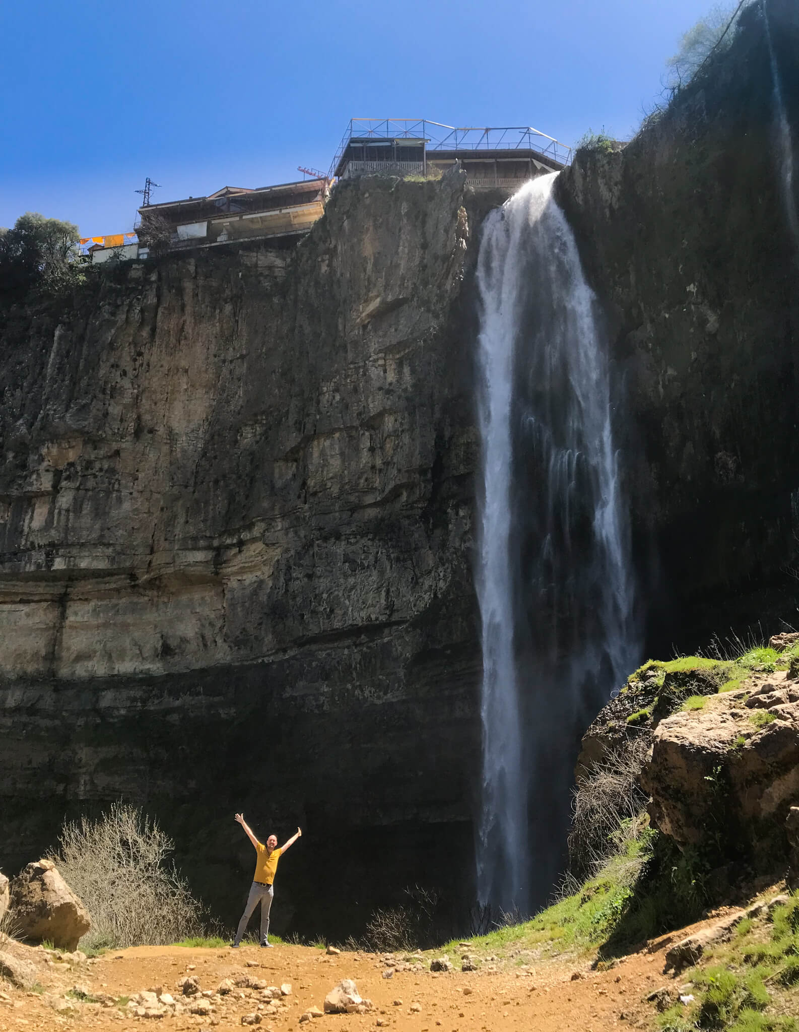 Me, standing at the bottom of Jezzine waterfall, with water pouring over the cliff behind me.