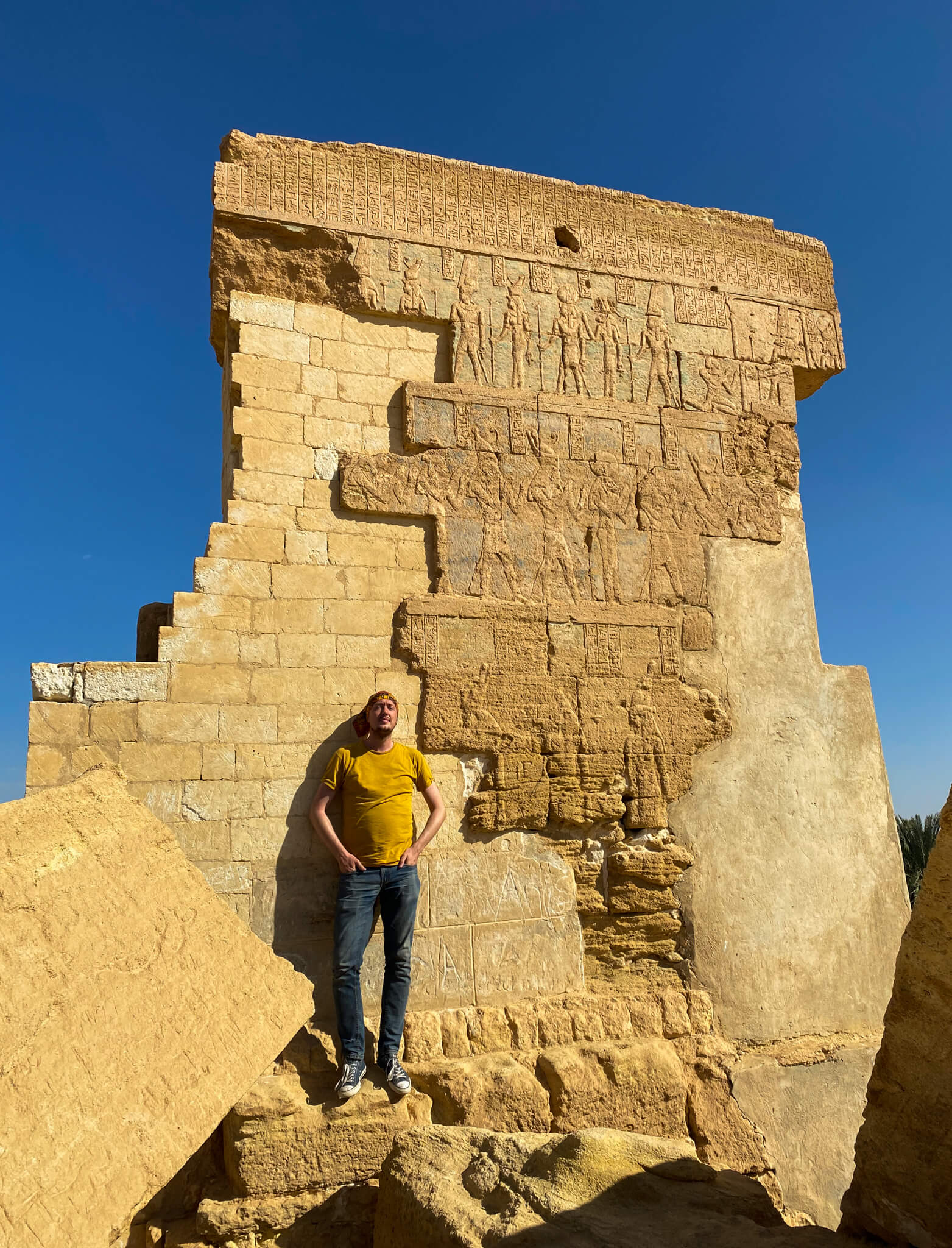 Me standing in front an ancient wall covered in ancient drawings.