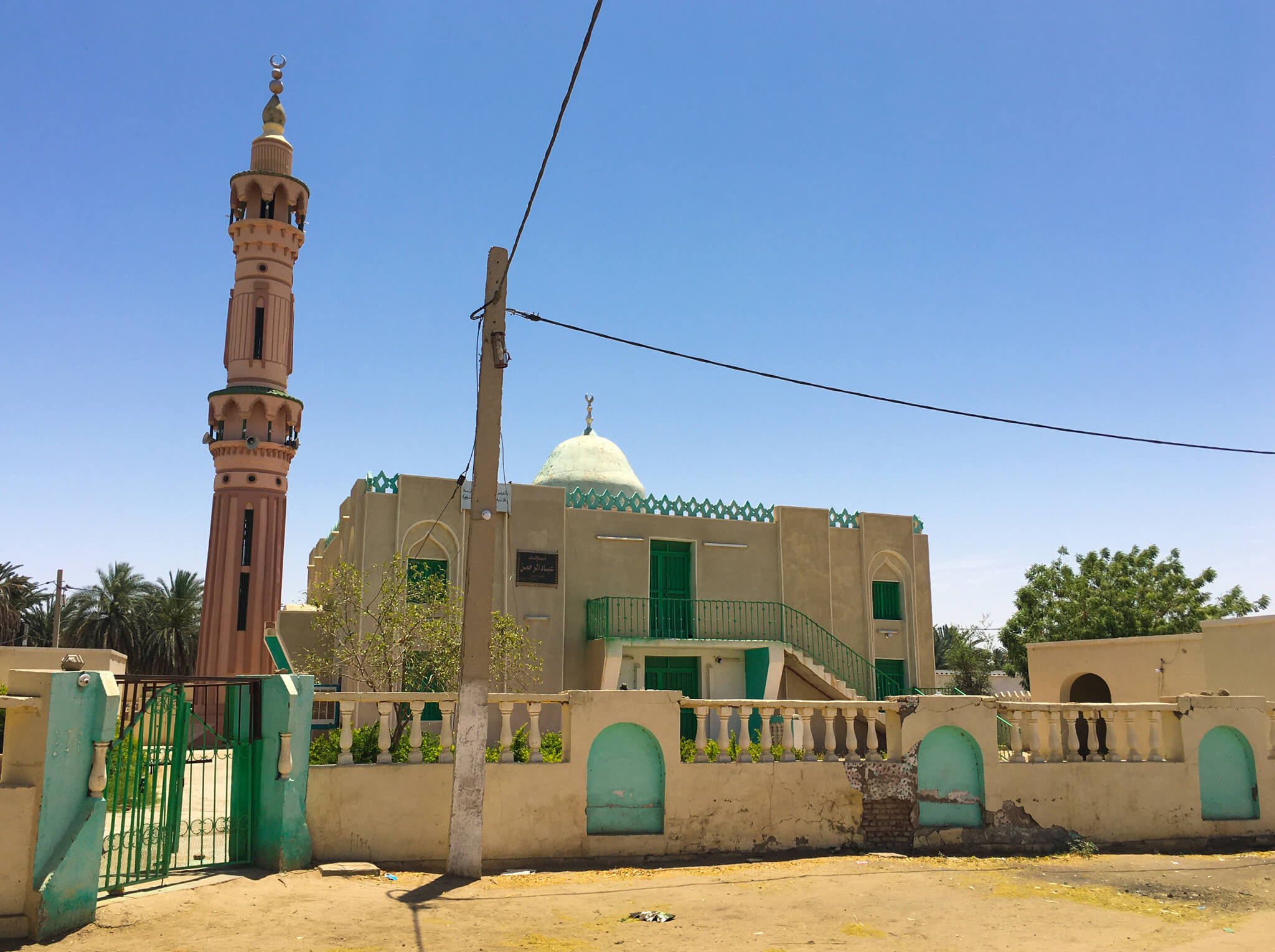 A beige and green mosque in Kerma.