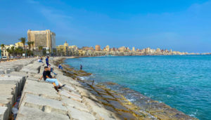 Alexandria Corniche and harbour in the sunshine with kids fishing in the sea
