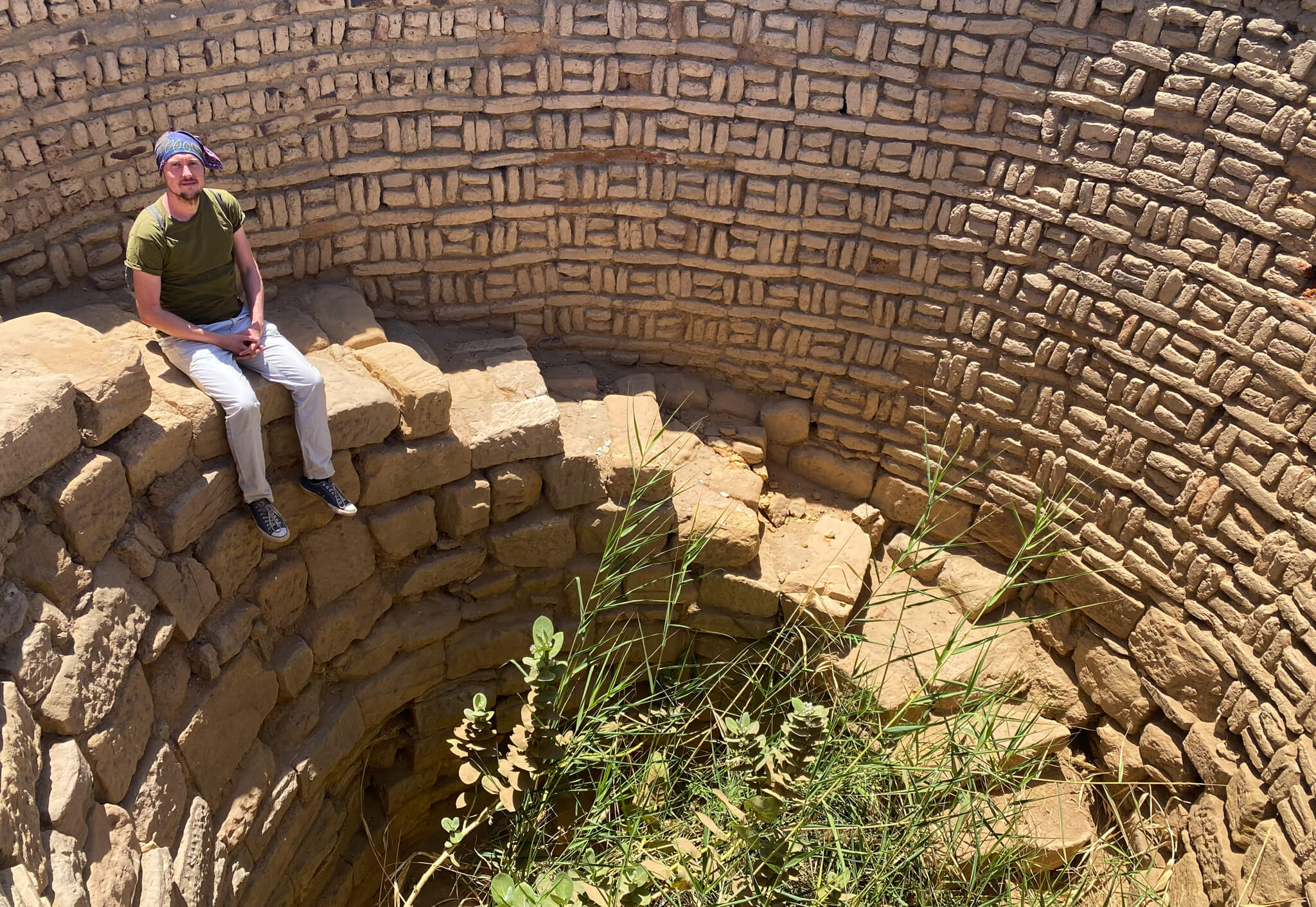 Me, sitting on a spiral staircase that winds down into a giant brick well.