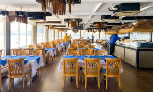 Tables laid at Fish Market restaurant, with the day's catch on a bar with ice on one side.