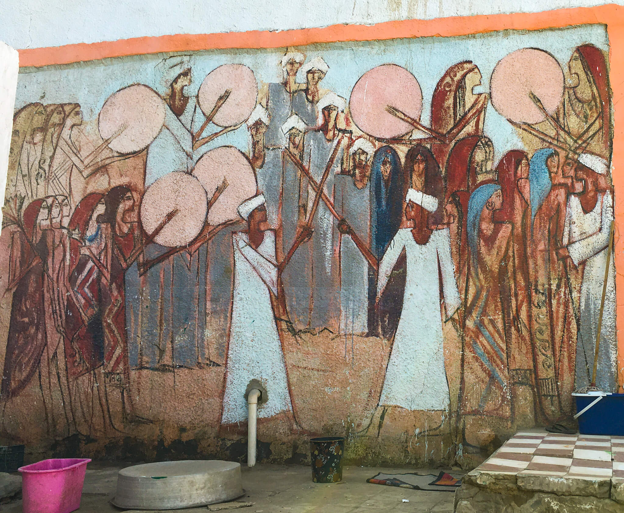 A Nubian drawing on a wall that appears to show two people fighting while others clap or bang drums.