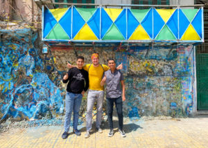 Me, standing in front of a wall taking a photo with two local boys we met on the street.