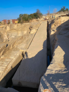A huge obelisk half carved out of the rock ground.