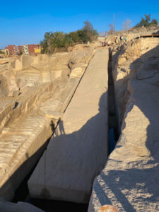 A huge obelisk half carved out of the rock ground.