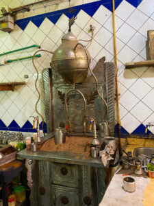 A machine for heating water using hot sand, with a metal water tank at the top and a fire underneath to heat the sand.