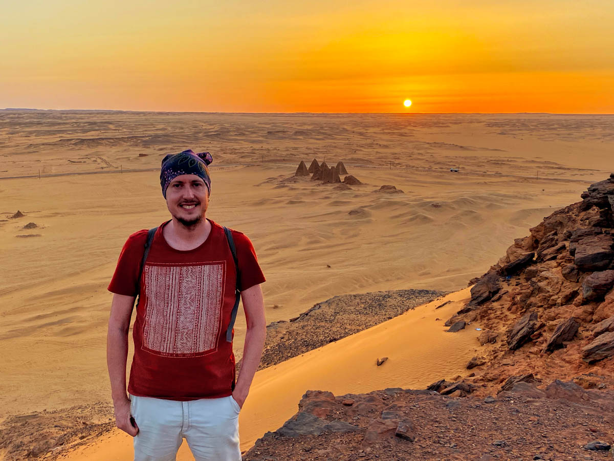 Me, standing in front of the Barkal Pyramids, with the sun setting over the horizon.