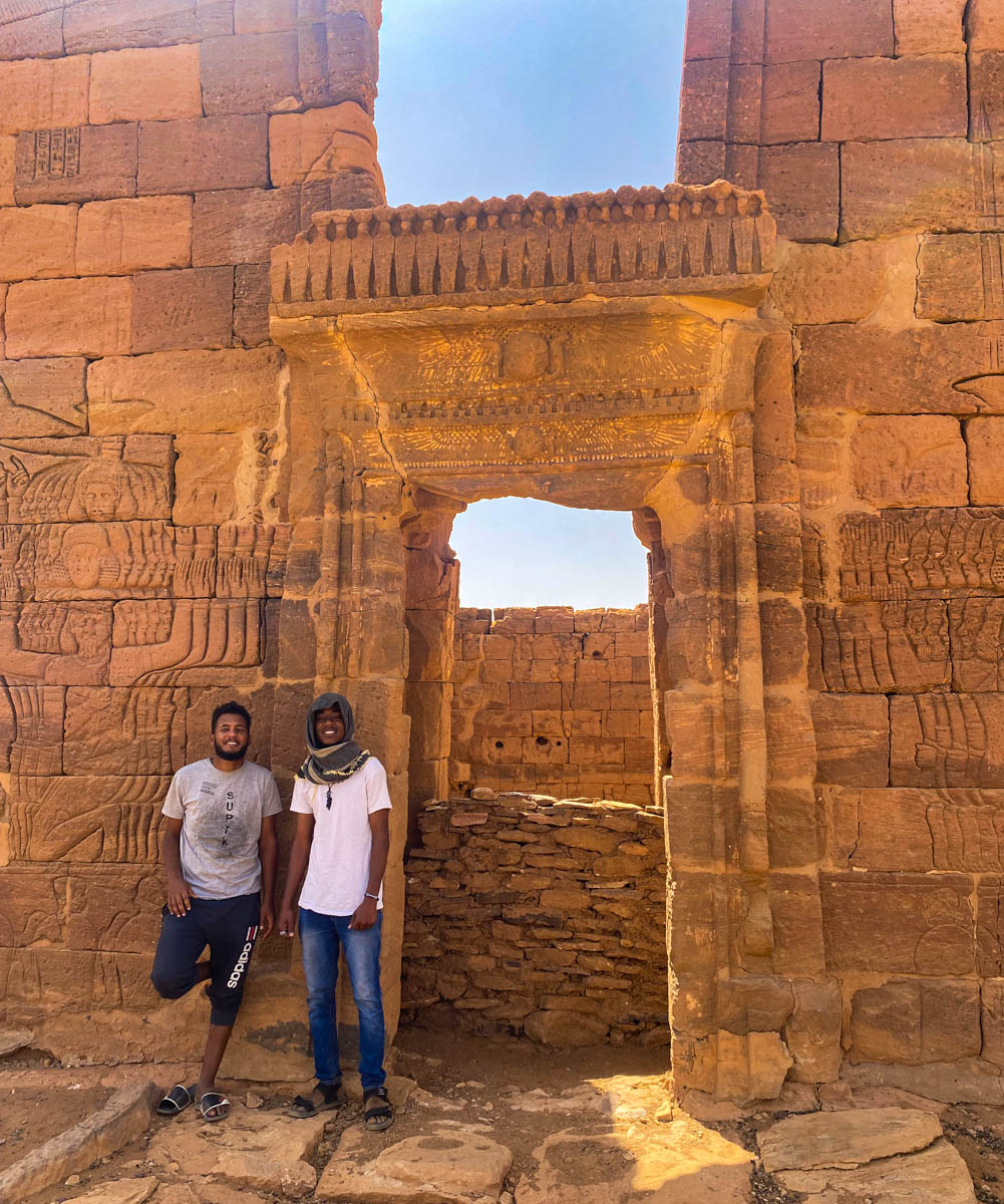 Two local guys standing by the beautifully carved entrance to the Apedemak in Naqa.