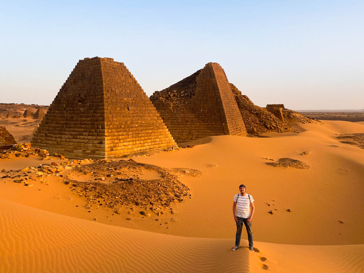 Me, standing a distance in front of two of the Pyramids of Meroe with the golden sands rolling away behind me.