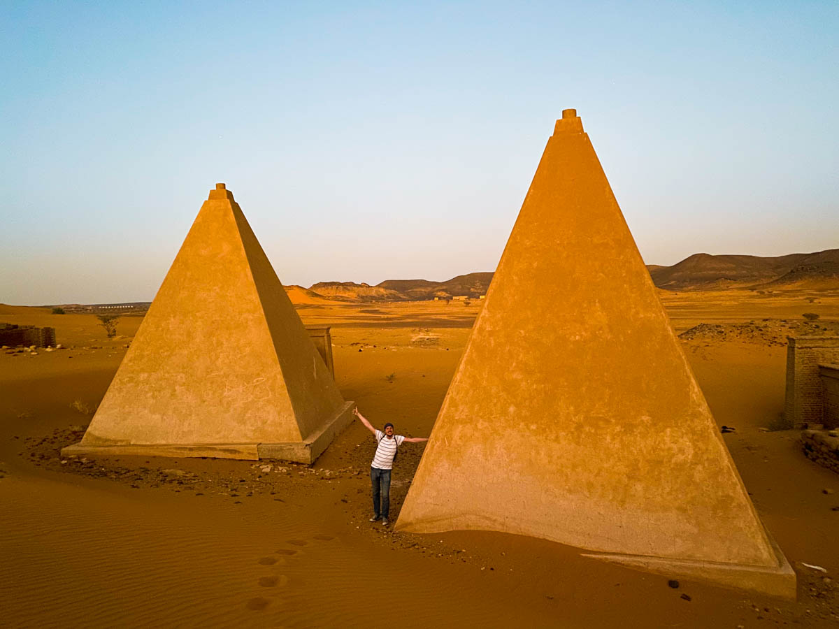 Me standing next to two very pointed pyramids that have been renovated