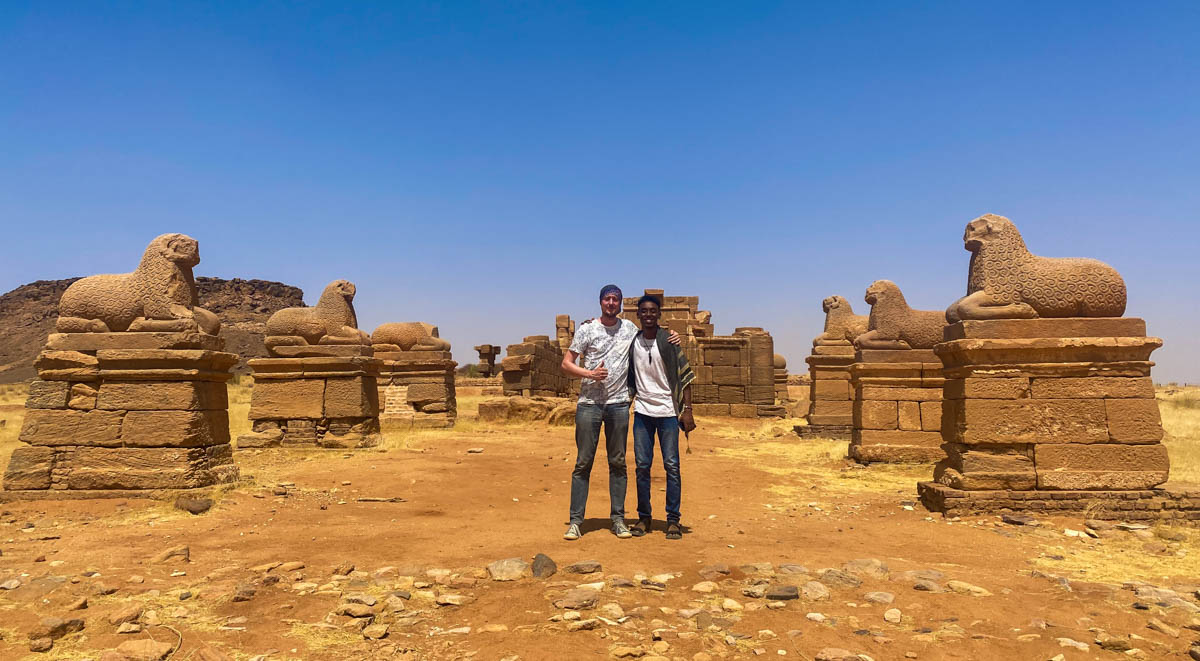 Me and a local friend standing between two rows of ram statues at the Temple of Amun
