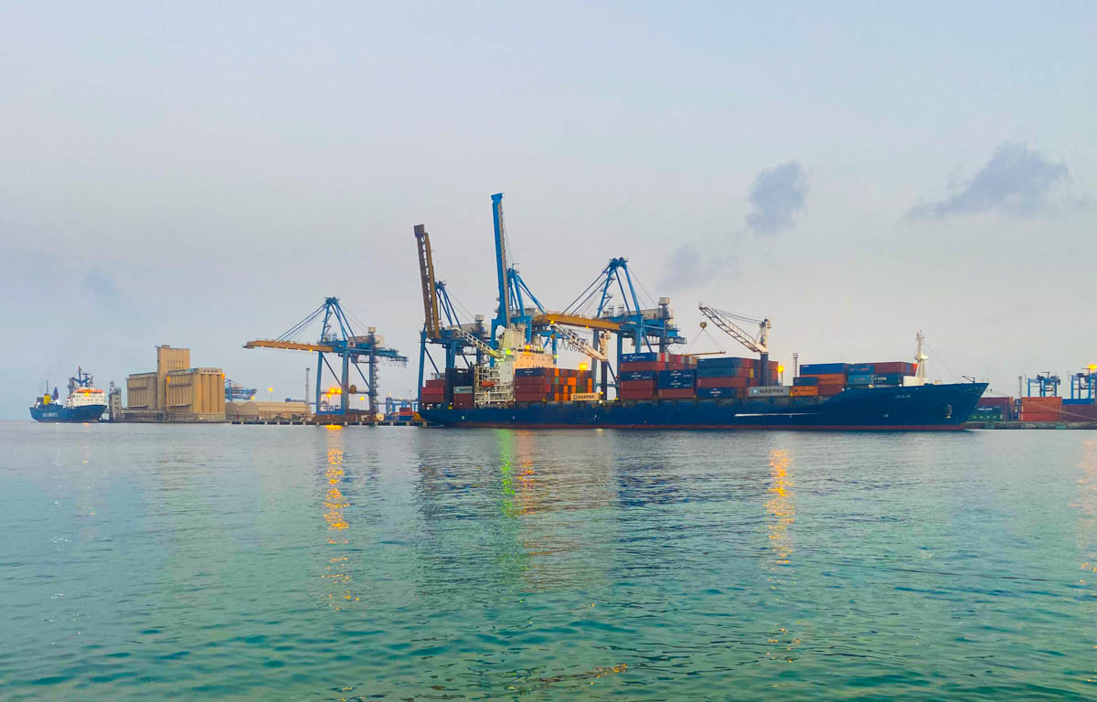 A container ship unloading across the bay.