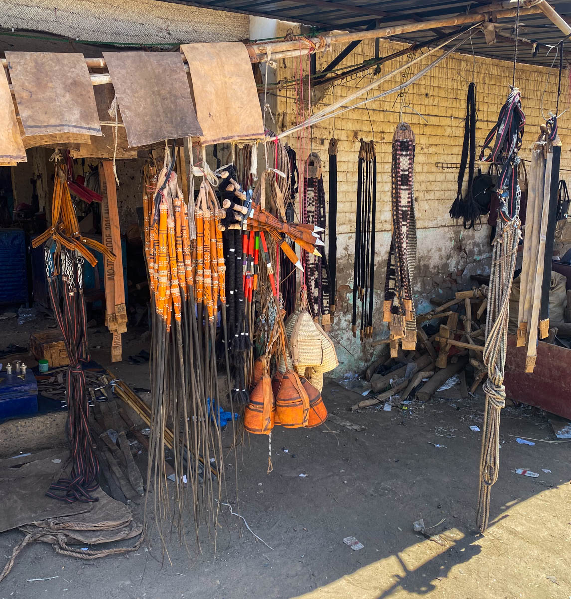An large assortment of different types of whip hanging outside a shop.